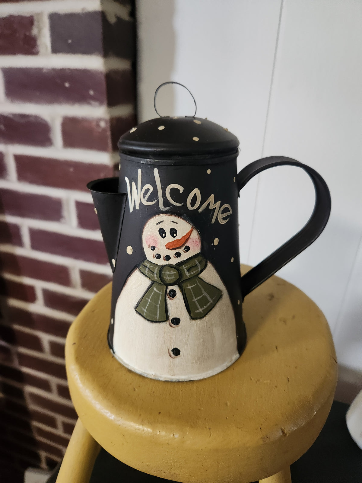 Black teapot with snowman welcome