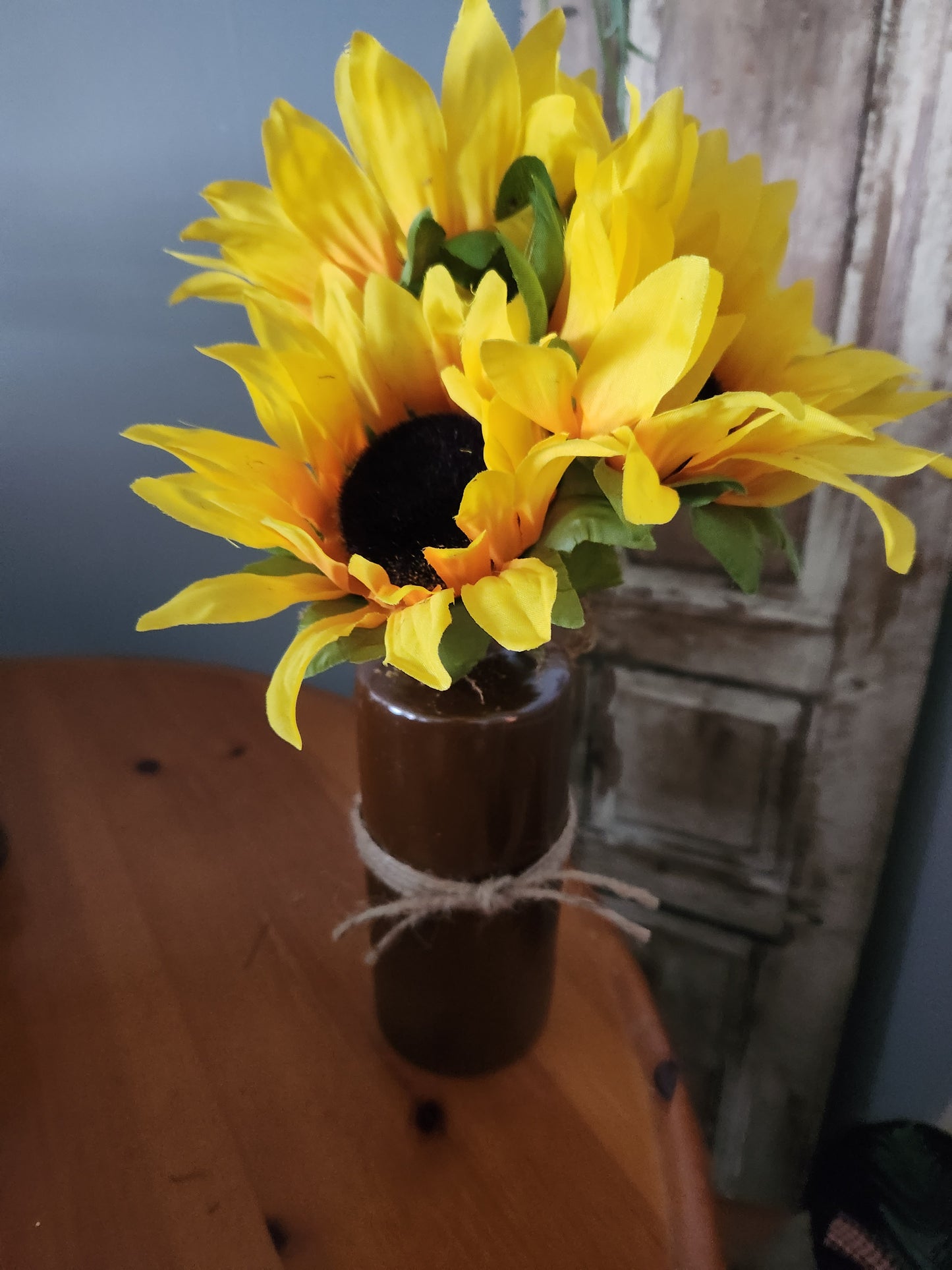 Sunflower arrangement in brown pottery vase