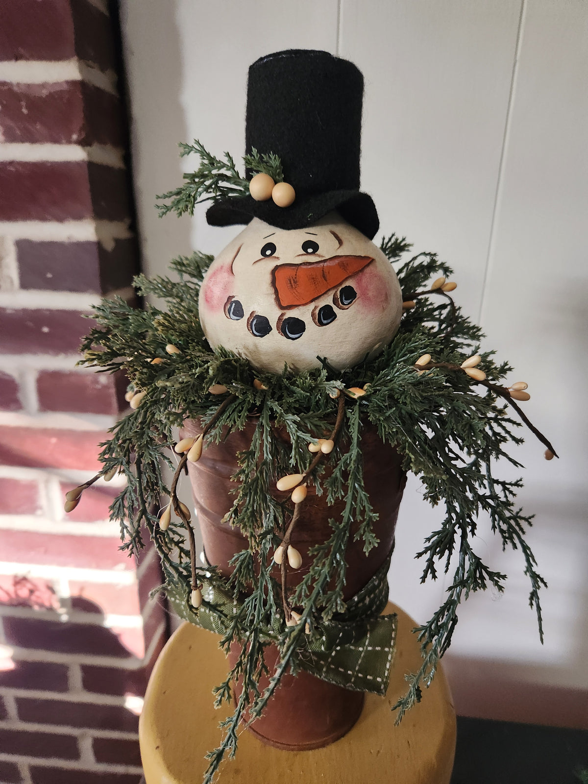 Snowman gourd arrangement on tall rusty tin