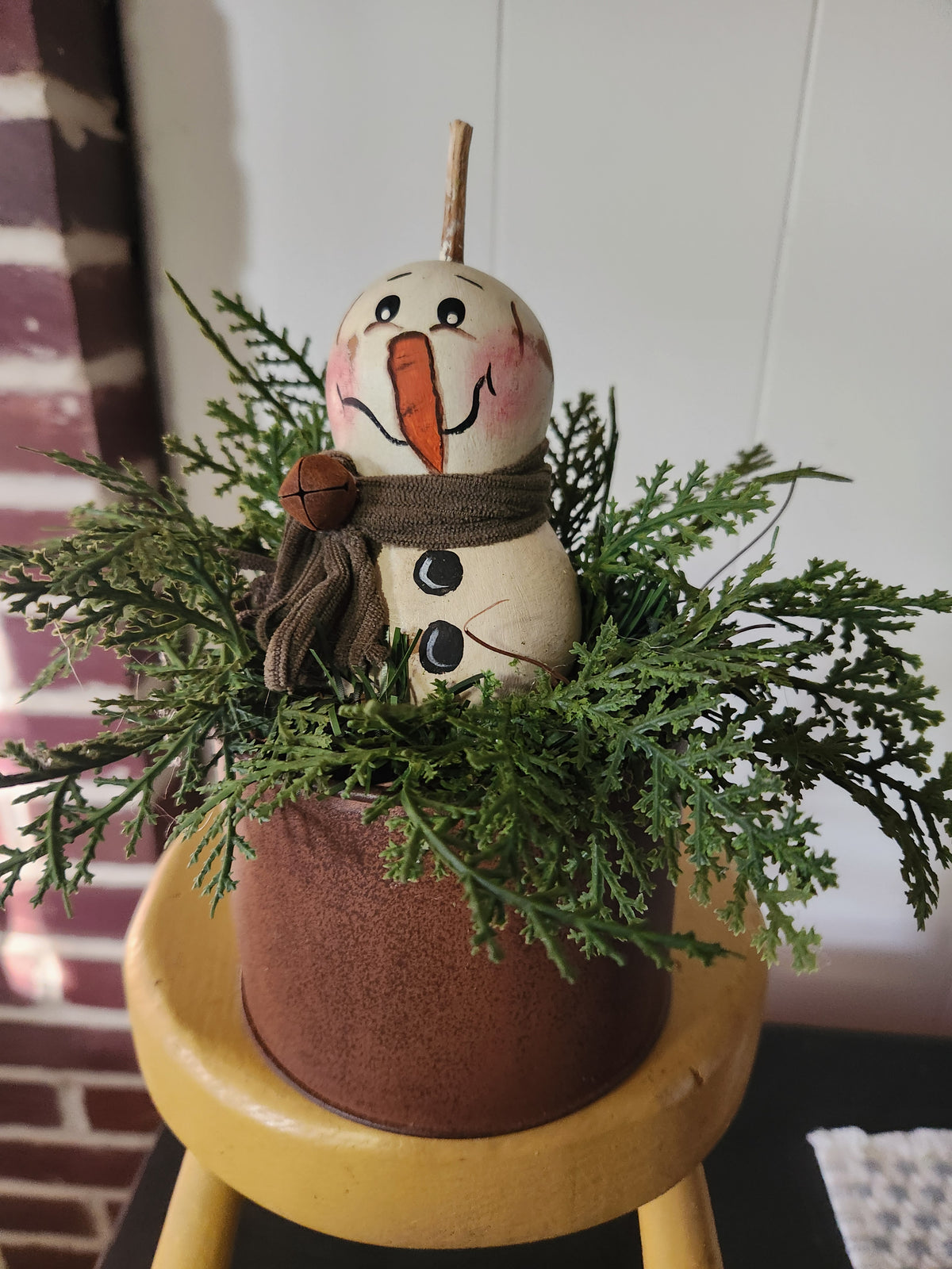 Snowman gourd arrangement in rusty container