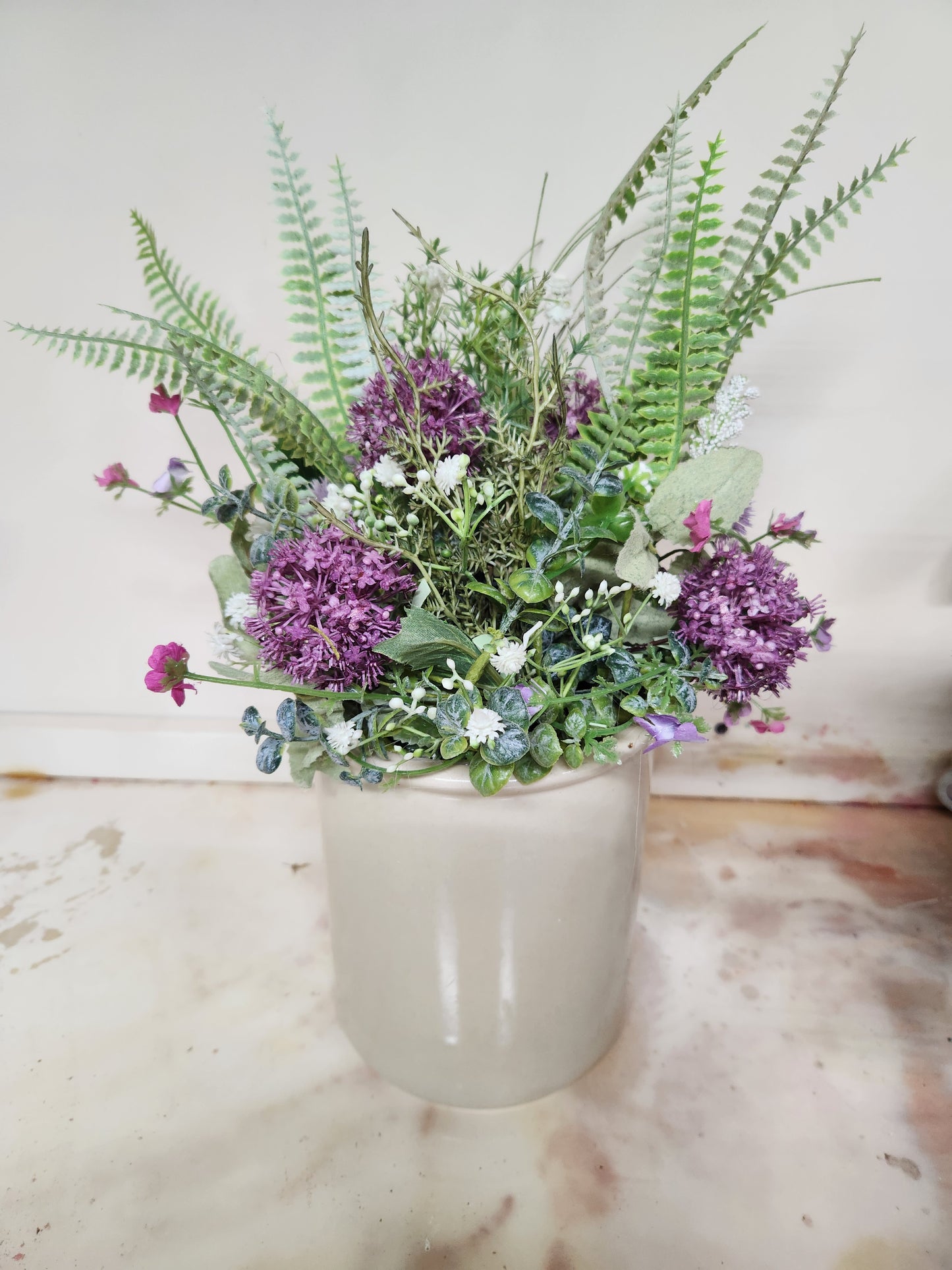 Purple arrangement in crock