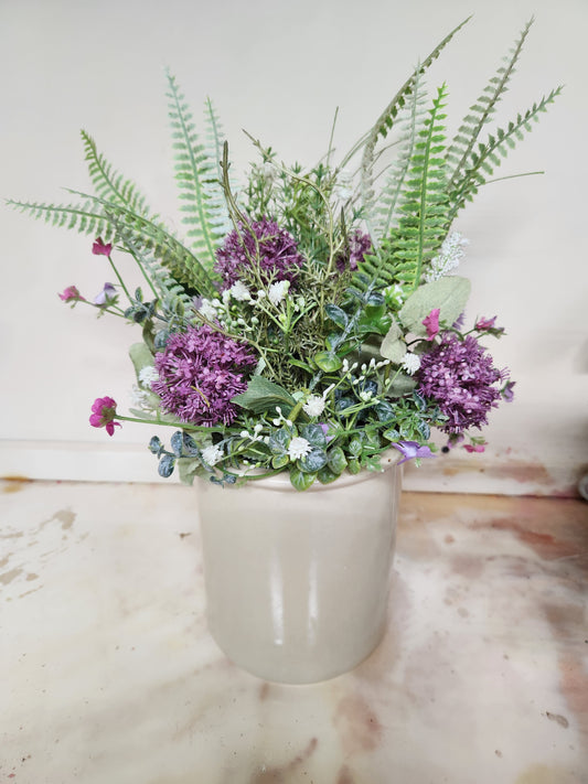 Purple arrangement in crock